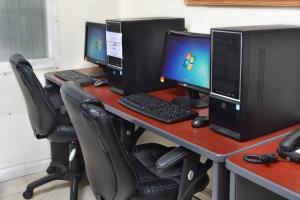 a desk with three computer monitors and a keyboard at Coral Mist Beach Hotel in Bridgetown