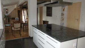 a kitchen with a black counter top and a dining room at Stuifenblick in Waldstetten