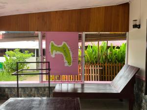 une porte rose avec un dinosaure peint sur elle dans l'établissement EL Homestay Bunaken, à Bunaken