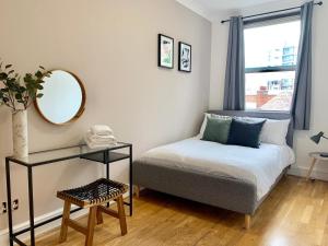 a small bedroom with a bed and a mirror at Chancery Lane Residenses in London