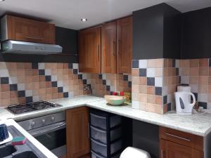 a kitchen with wooden cabinets and a stove top oven at Jasmine Haus in Moortown