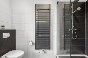 a bathroom with a shower with a toilet and a glass door at Elegant & Bright ~ Near Schalke 04 ~ Office ~ Free Parking! in Gelsenkirchen +13 photos