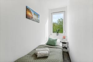 a small bedroom with a bed and a window at Elegant & Bright ~ Near Schalke 04 ~ Office ~ Free Parking! in Gelsenkirchen
