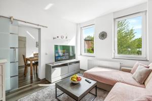 a living room with a couch and a tv at Elegant & Bright ~ Near Schalke 04 ~ Office ~ Free Parking! in Gelsenkirchen