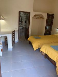 Zimmer mit 2 Betten, einem Tisch und einem Spiegel in der Unterkunft Azzaouia Resort in Tahla