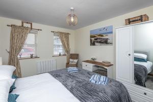 a bedroom with a bed and a desk in it at Penrhyn Cottage in Cemaes Bay