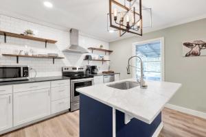 a kitchen with white cabinets and a blue island at Get Your Kicks on 86th-Airport-Museum of Flight in Birmingham