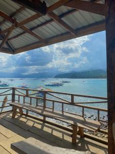 un banco de madera sentado en un balcón con vistas al océano en Cafe Sabang Guest House en Sabang