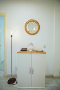 a white cabinet with a mirror on a wall at Sol & Mar apartment in Fuengirola