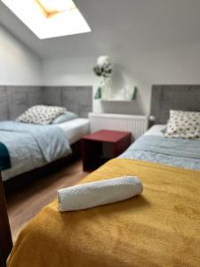 un mando a distancia sentado en una cama en un dormitorio en Szumi Las Bed & Breakfast, en Józefów