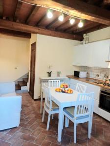 uma cozinha com uma mesa branca e cadeiras num quarto em Casa vacanze La Cerrina em Gambassi Terme