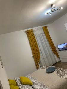 1 Schlafzimmer mit 2 Betten und gelben Kissen in der Unterkunft Savonarola residence in Alessandria