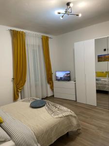 um quarto com uma cama e uma televisão em Savonarola residence em Alessandria