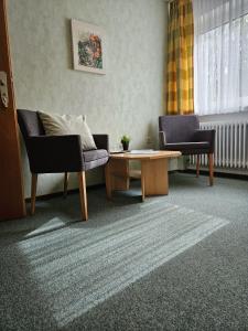 a living room with two chairs and a coffee table at Gasthof zur Burgruine in Pottenstein