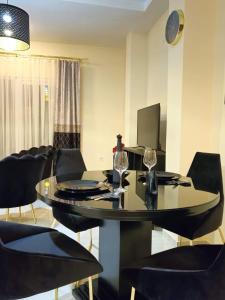 a dining room with a table with chairs and a television at Merter Apartments in Kavadarci