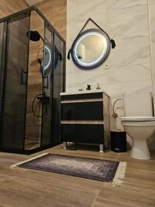 a bathroom with a sink and a shower with a mirror at Merter Apartments in Kavadarci