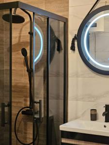 a bathroom with a shower with a sink and a mirror at Merter Apartments in Kavadarci