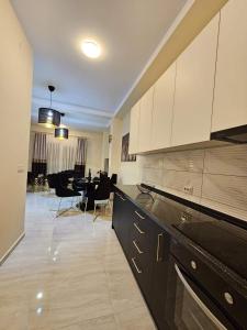 a kitchen with white cabinets and a dining room at Merter Apartments in Kavadarci