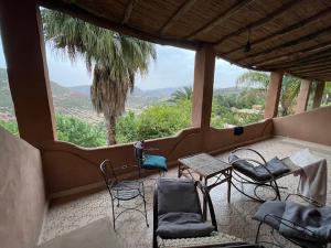 einen Balkon mit Stühlen und Tischen sowie Bergblick in der Unterkunft Azzaouia Resort in Tahla