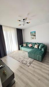 una sala de estar con un sofá verde en una habitación en The Sea Escape Apartment, en Constanţa