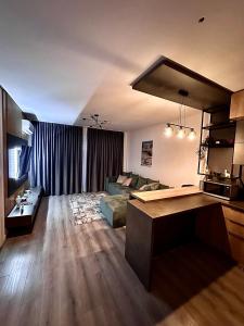 sala de estar amplia con sofá y cocina en The Sea Escape Apartment, en Constanţa