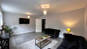 a living room with a couch and a table at Spacious 4 Bedroom New-build N2 in Aldershot