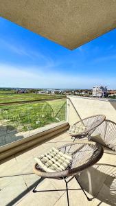 a wicker chair sitting on a balcony with a view at The Sea Escape Apartment in Constanţa +20 photos