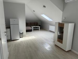 an empty living room with a kitchen and a couch at XL Apartman in Teslić