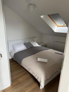 a bedroom with a large bed with a skylight at XL Apartman in Teslić