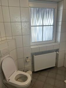 a bathroom with a toilet and a window at Ferienglück am Spielplatz in Günzburg