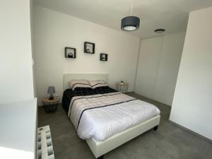 ein Schlafzimmer mit einem Bett in einem weißen Zimmer in der Unterkunft Maison en pierre à la campagne in Ploëzal