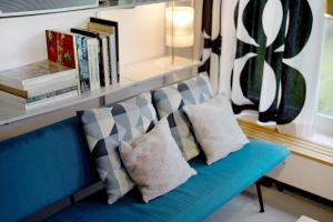 a blue couch with pillows and a shelf with books at Haus Erika in Alpirsbach