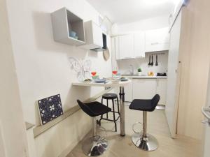 una piccola cucina con tavolo e due sgabelli di Incantevole Monolocale Balilla Centralissimo Int 3 a San Benedetto del Tronto