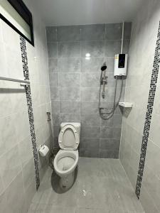 uma casa de banho com um chuveiro e um WC. em BIG BEN Residence em Kaeng Khoi