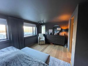 een slaapkamer met een bed, een dressoir en een spiegel bij Spacious & luxurious family home w hot & cold tub & sauna in Reykjavík