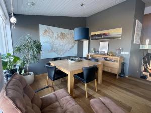 een woonkamer met een houten tafel en stoelen bij Spacious & luxurious family home w hot & cold tub & sauna in Reykjavík