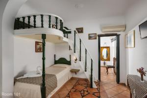 a bedroom with a bunk bed and a spiral staircase at Voreades in Tinos Town