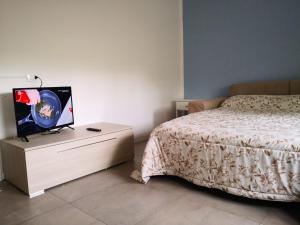 um quarto com uma cama e uma televisão numa cómoda em Bergamo Centro Residence em Bérgamo