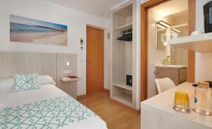 a hotel room with a bed and a bathroom at Hotel Colonial in Colonia Sant Jordi
