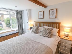 um quarto com uma cama grande e uma janela em 2 Engine House em Lyme Regis