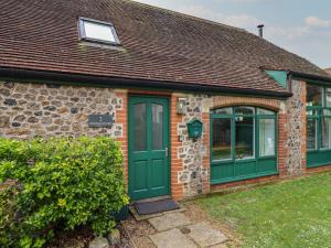 uma casa de tijolos com portas verdes e uma janela em 2 Engine House em Lyme Regis