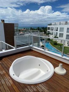 eine weiße Badewanne auf einer Terrasse auf einem Balkon in der Unterkunft Condomínio na praia em Nísia Floresta - Tabatinga - Natal/RN in Nísia Floresta