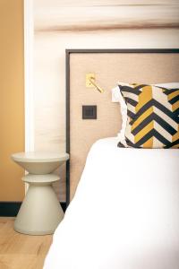 1 dormitorio con 1 cama y reloj en la pared en Hotel Ker Moor Saint-Quay Portrieux en Saint-Quay-Portrieux