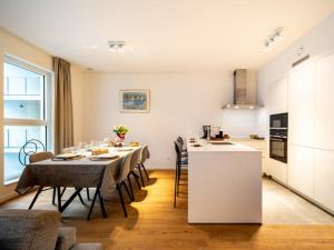 cocina y comedor con mesa y sillas en Jolie appartement haut standing Liège Guillemins en Lieja