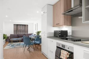 Una cocina y una sala de estar con mesa y sillas. en Digbeth Luxury Apartment, en Birmingham