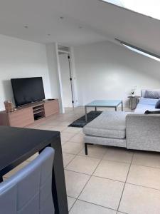 un soggiorno con un divano e una TV di Studio 177 a Waregem