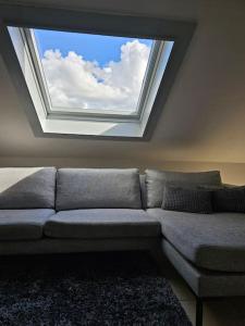 - un canapé dans une chambre avec une grande fenêtre dans l'établissement Studio 177, à Waregem