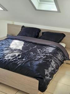 un letto con piumone e cuscini neri di Studio 177 a Waregem