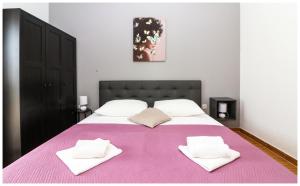 a bedroom with a large bed with a pink blanket at M&Z Apartmani in Primošten