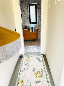 a hallway with a bathroom with a rug and a mirror at Adventure Camp Schnitzmühle in Viechtach